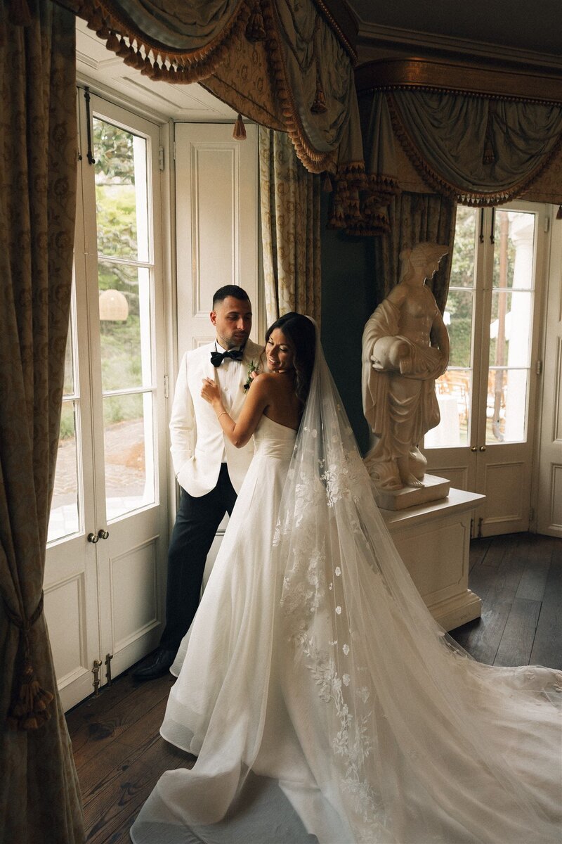 A bride and groom standing by a window at William Aiken house in Charleston sc