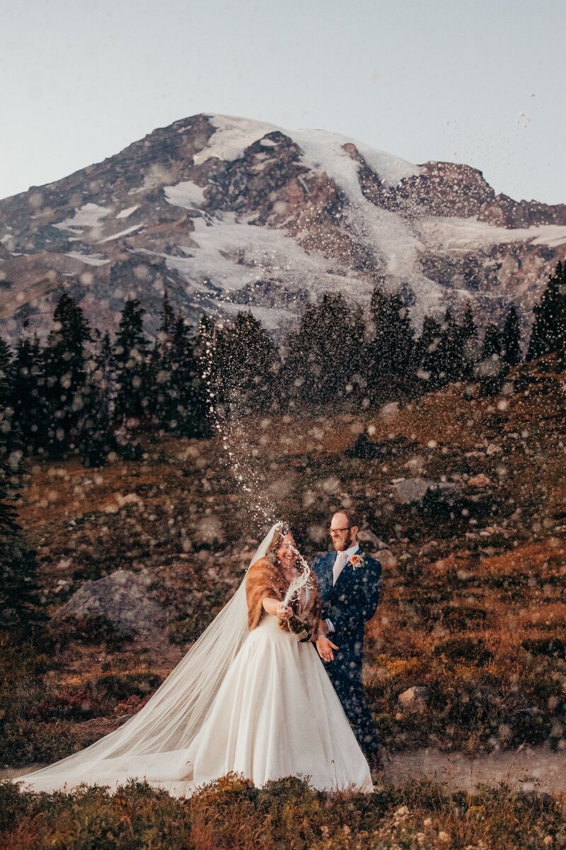 Couple popping champagne during their elopement at Mt. Rainier | Megan Montalvo Photography