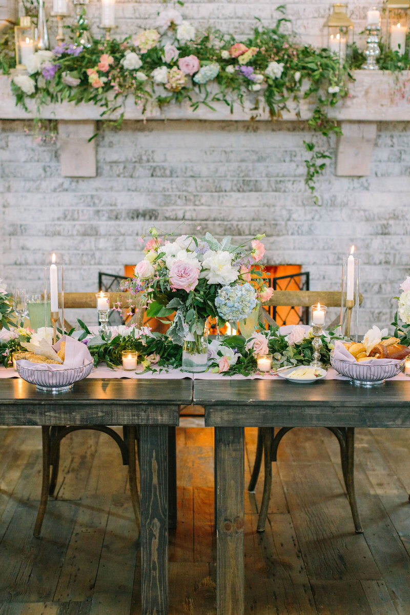Outdoor wedding reception with flowers and candles by fireplace