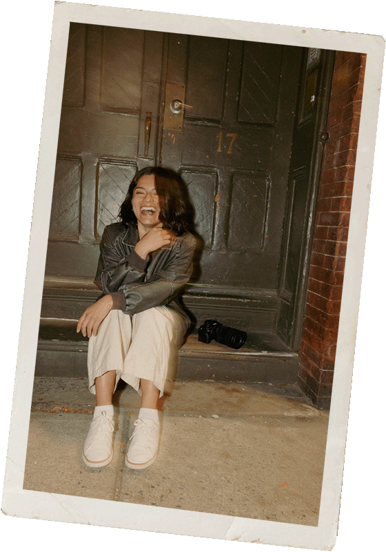 Flash photography portrait of a New York Wedding Photographer laughing outside at night in front of an old door