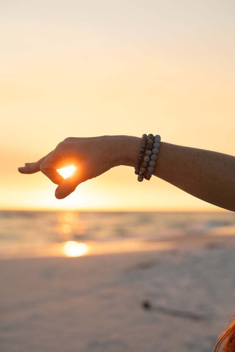 hand making the om sign by the sun 