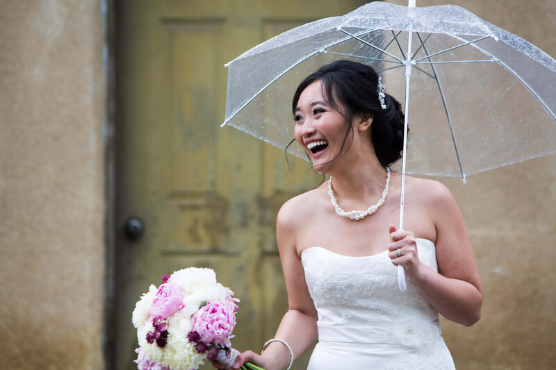 bride laughing under umbrella