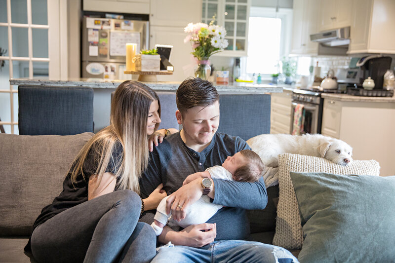 couple holding newborn baby in home