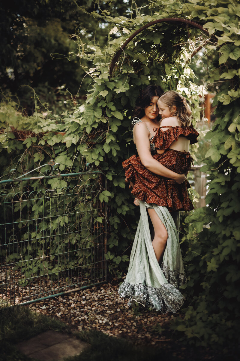 A mother stands with her daughter in a tunnel of ivy at the urban farmhouse in Boise Idaho. 