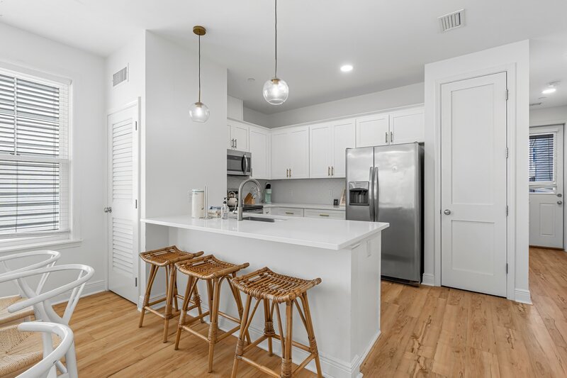 Modern open kitchen with breakfast bar and coastal touches at Beach Cabana vacation rental in Panama City Beach, minutes from 30A and Carillon Beach.