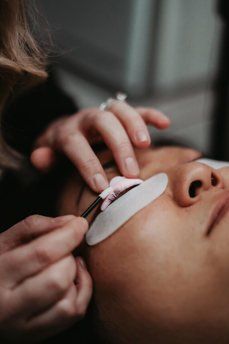 close up of a beauty technician's hands as she carefully applies a lash lift in Green Bay WI