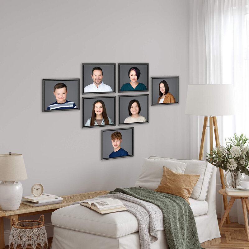 collection of family portraits hanging on a wall in a living room