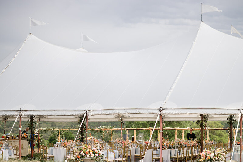 Outdoor sailcloth tent decorated with flowers and ready for reception