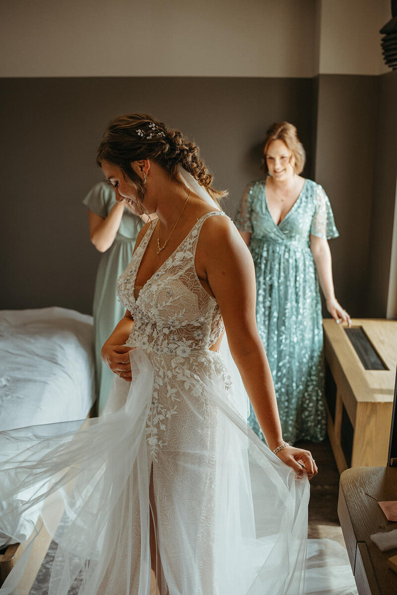 A person in a wedding dress twirling with two people smiling behind them 
