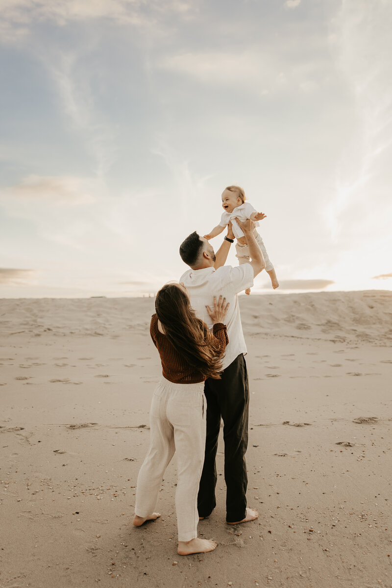 motherhood photography of mom hugging her children while sitting on a blanket at the beach in Lebanon, New Jersey