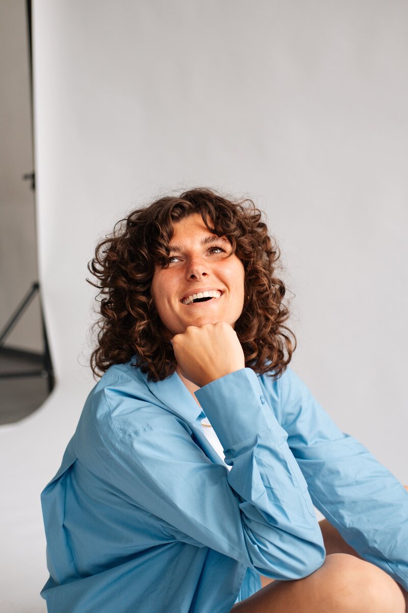 Studio Vers branding portret van lachende vrouw in blauwe blouse in fotostudio setting