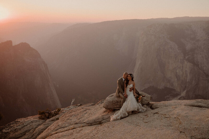 Bride and groom sit together on a rock at Taft Point