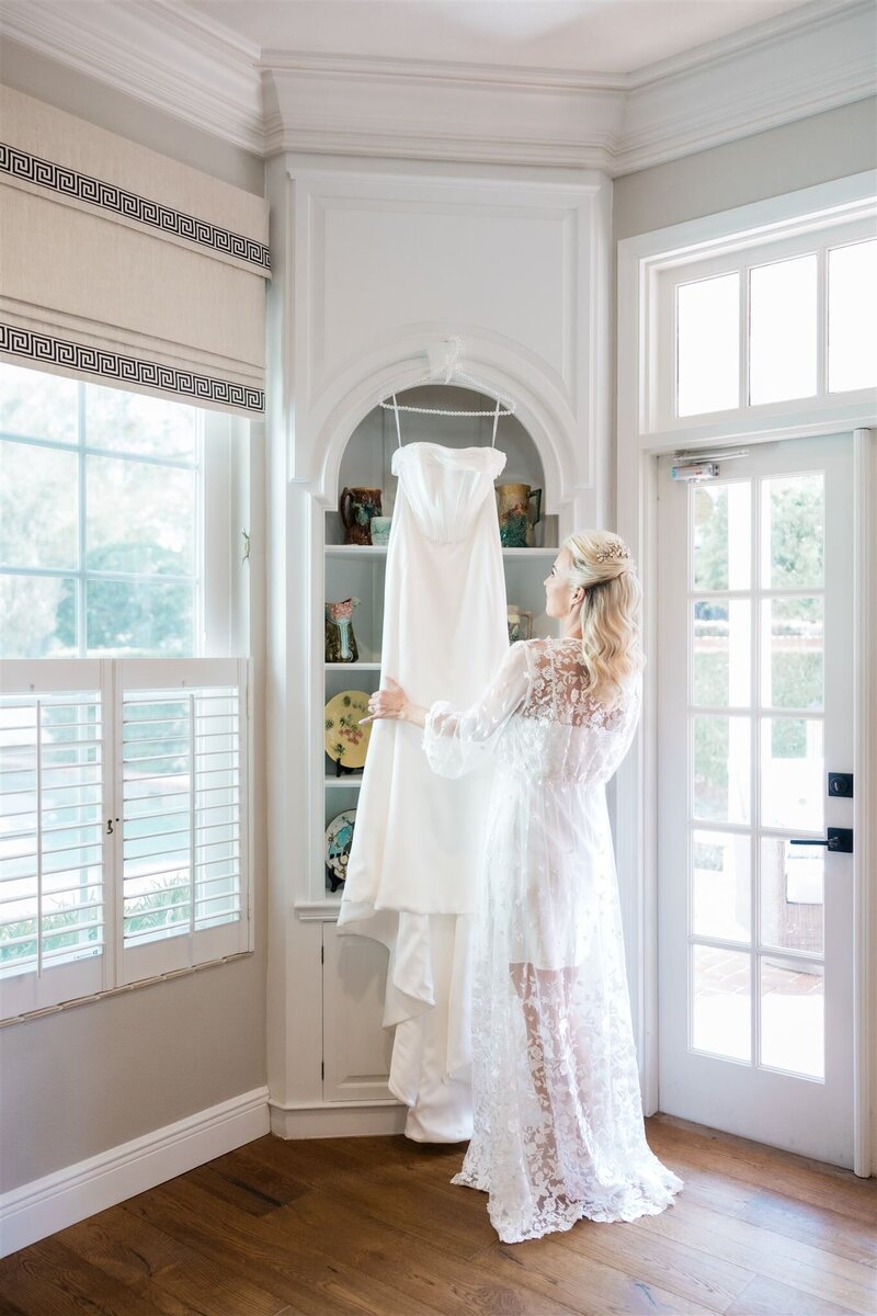 Bride looking at her dress by Florida wedding photographer