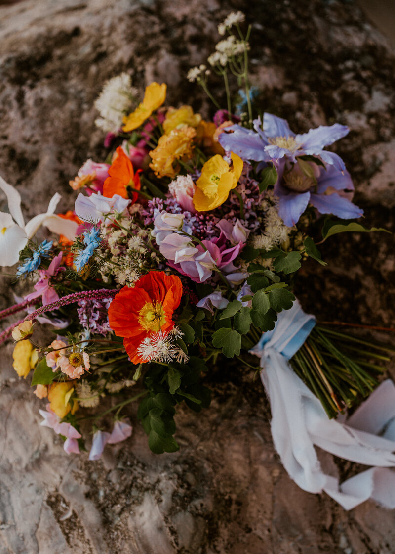 a brides bouquet sits casually on a rock during an Oregon coast elopement.