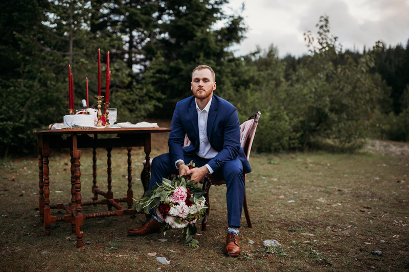 groom sitting by wedding table