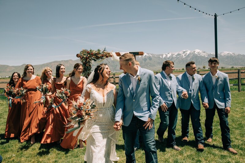 Bride with her bridesmaids holding light pink light peach and blue wedding party flowers