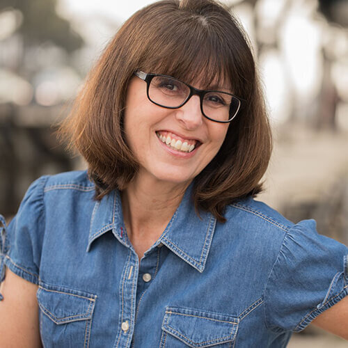 Headshot of Theresa Loe smiling wearing a denim shirt