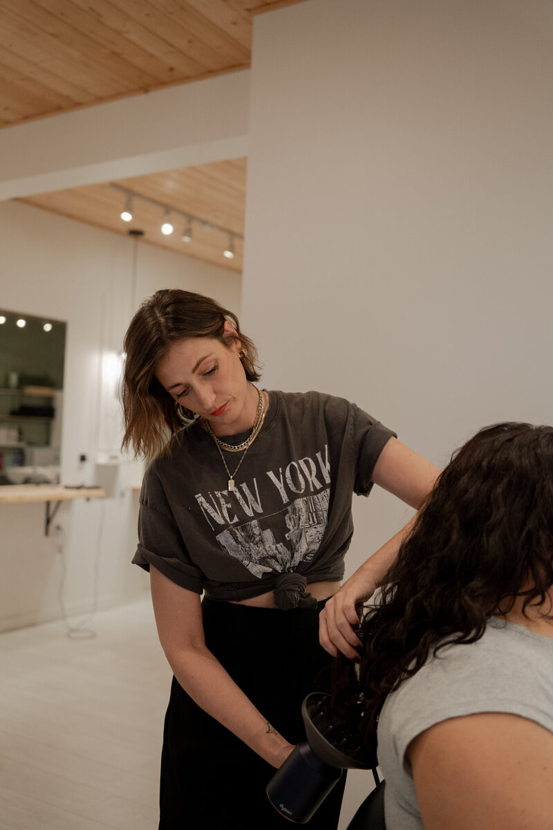 Woman curling a client's hair