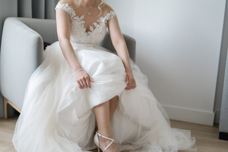 La mariée enfile son soulier pour compléter sa préparation dans un hôtel de la Rive-Sud de Montréal, moment délicat et raffiné capturé lors d’un mariage élégant au Québec
