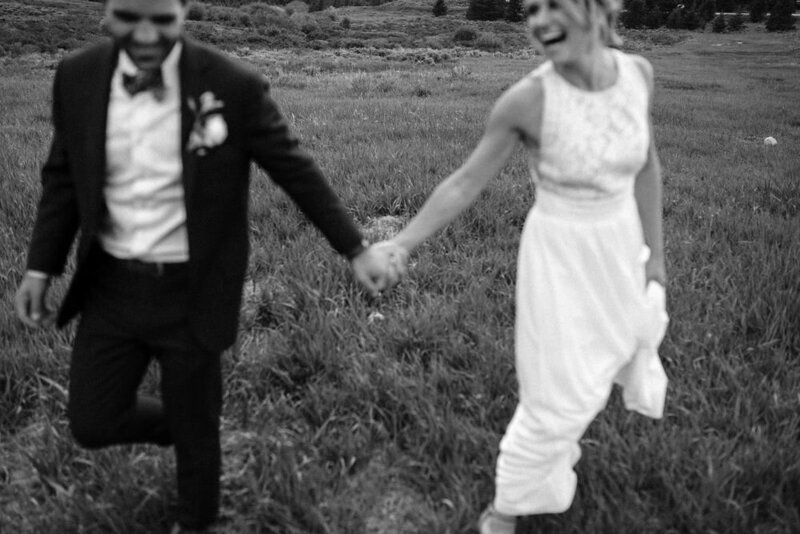 Candid photo of couple running around a field in Breckenridge