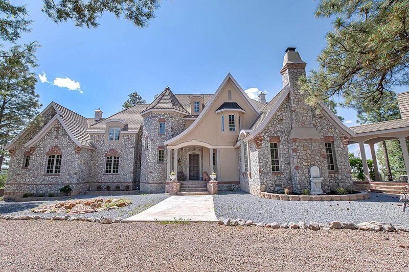 Ground view of a gorgeous stone chateau in a forest. 