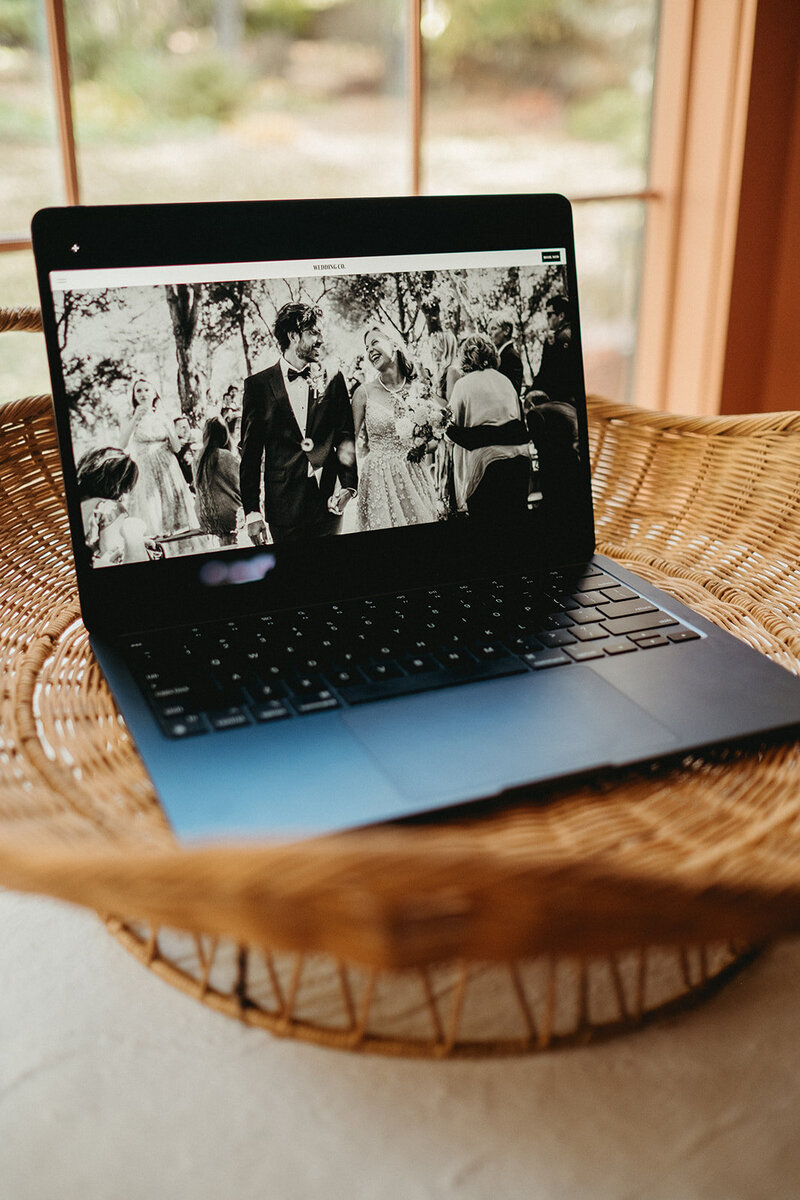 A laptop in basket showcasing a wedding website template