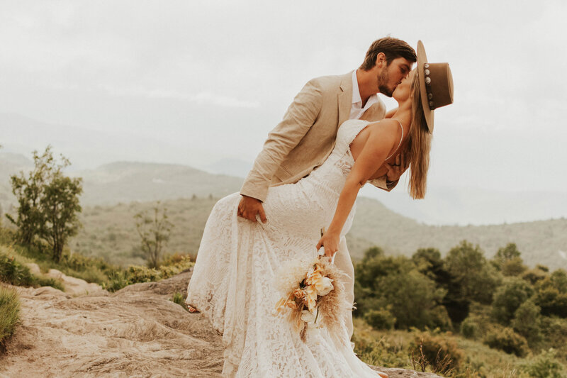 Adventurous couple embracing  and kissing in their elopement in NC
