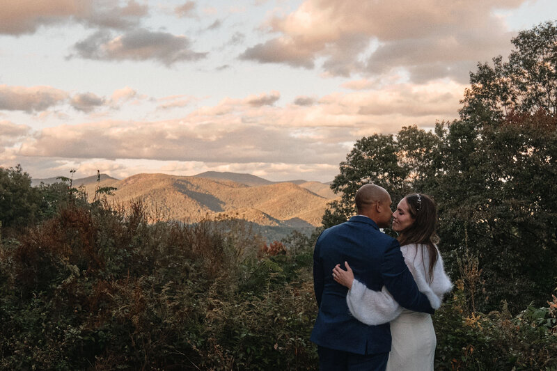 Elopement couple looking at each other as the sun sets in the mountains