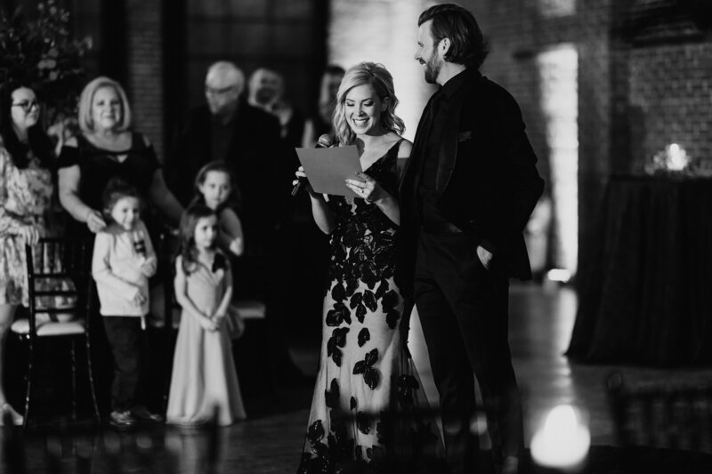 Bride in black floral wedding dress giving welcome speech at The Hudson - Alex Bo Photo
