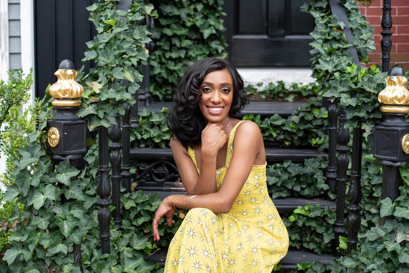 Georgetown DC black woman posing in yellow dress sitting on vine covered stairs