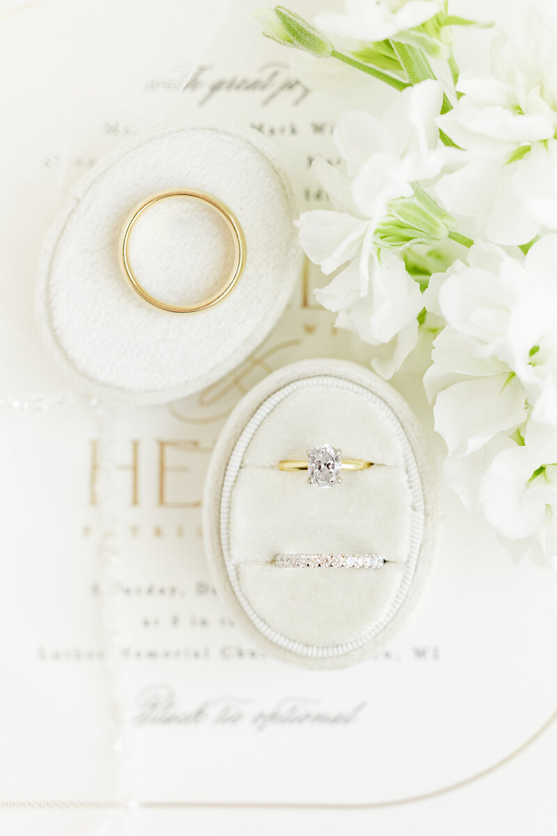 rings in velvet ring box on an invitation with white flowers