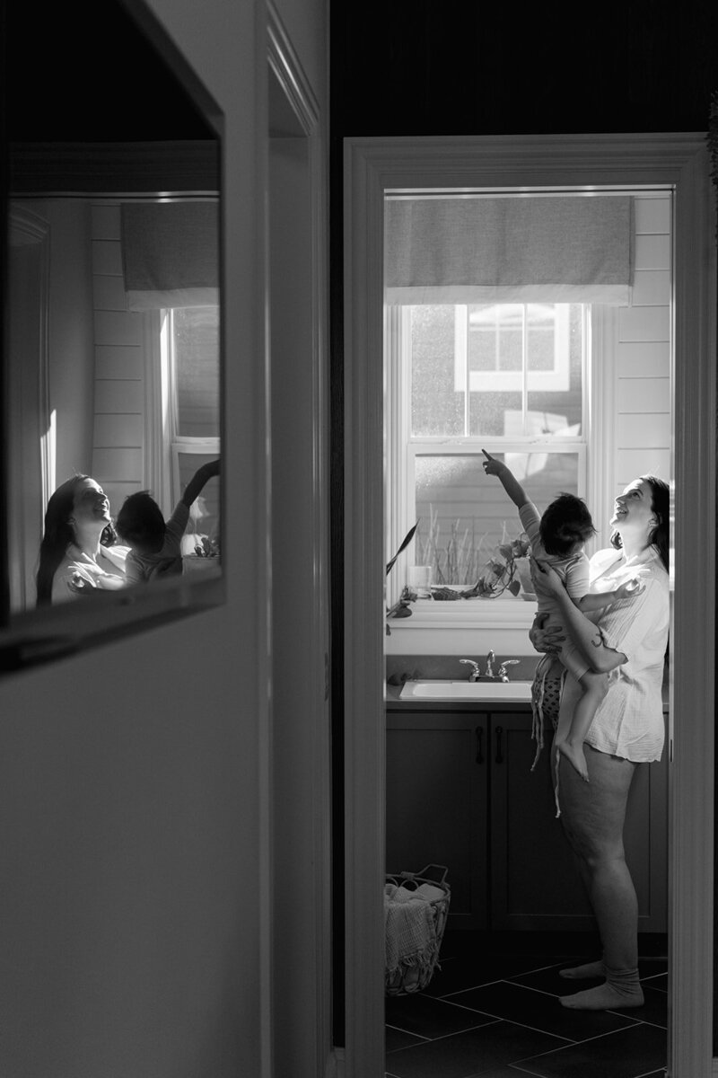 Pregnant woman holding her child in laundry room