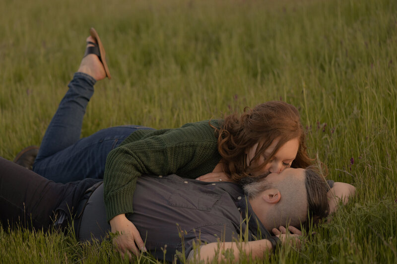 Couples Engagement Photos candid kissing and laying in green field on the Central Coast in San Luis Obispo 
