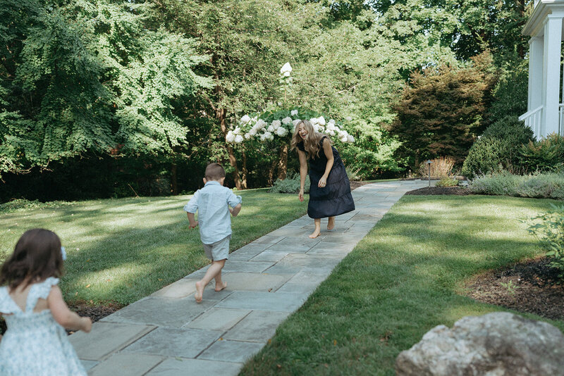 two kids running to mom during family photos captured by NYC family photographer Elsie Goodman