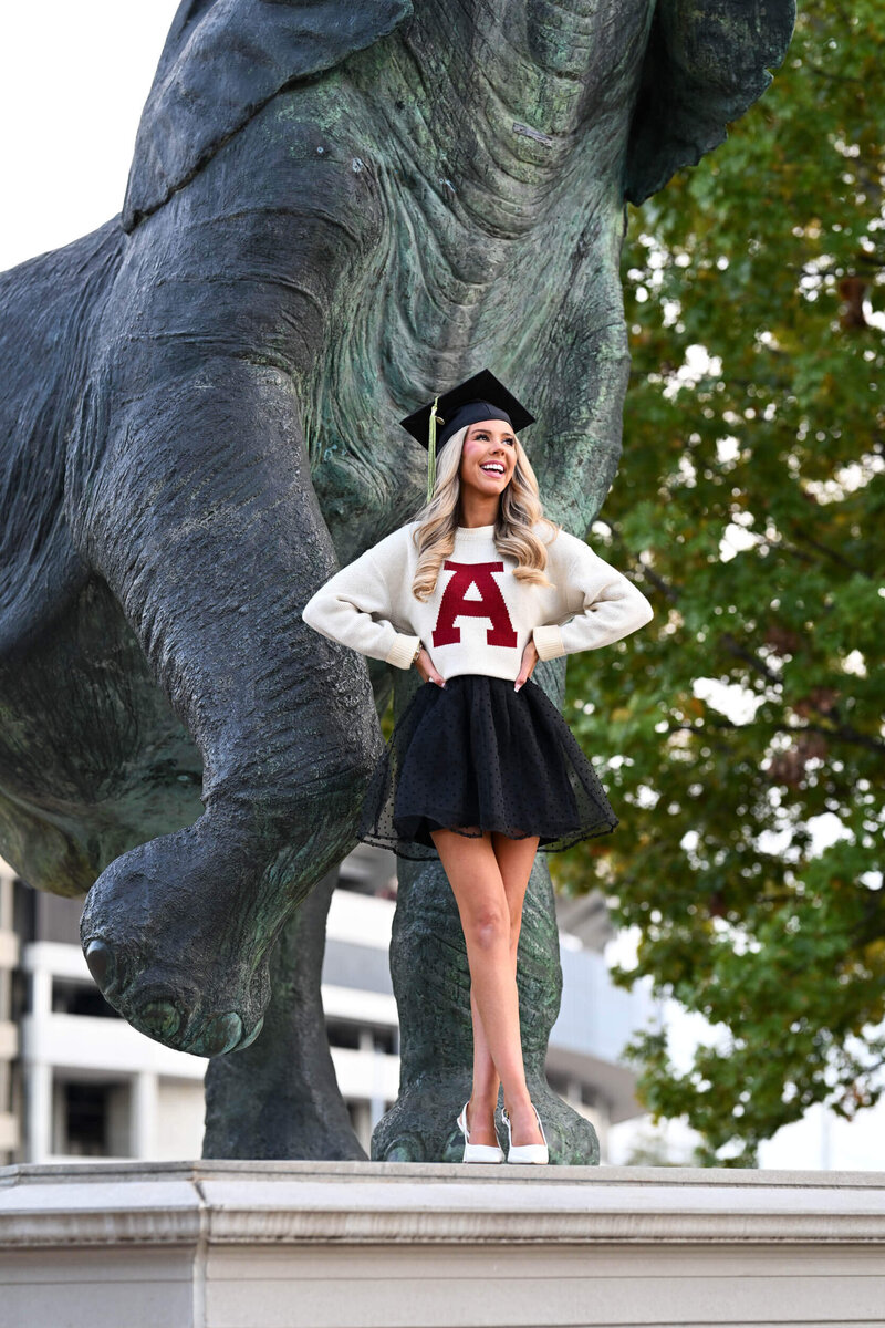 Senior Graduate standing in front of elephant statue