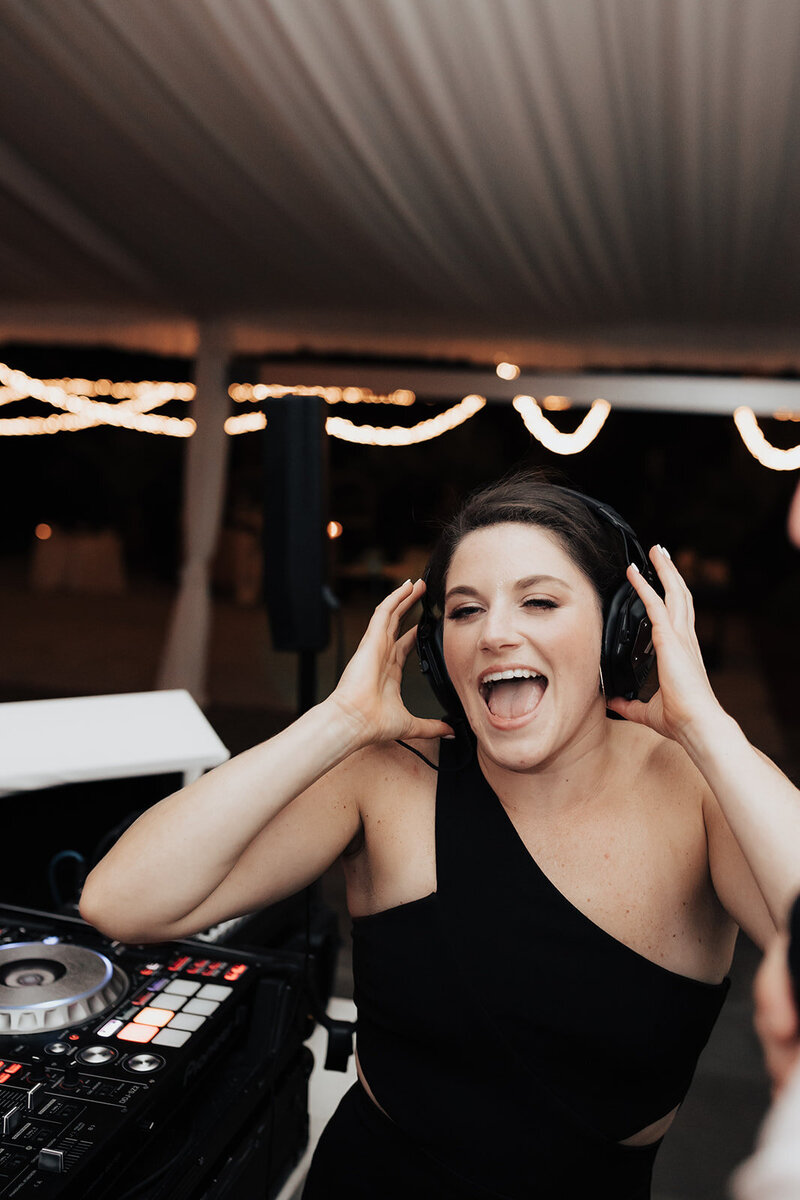 Bridesmaid with headphones next to DJ at lowndes grove wedding