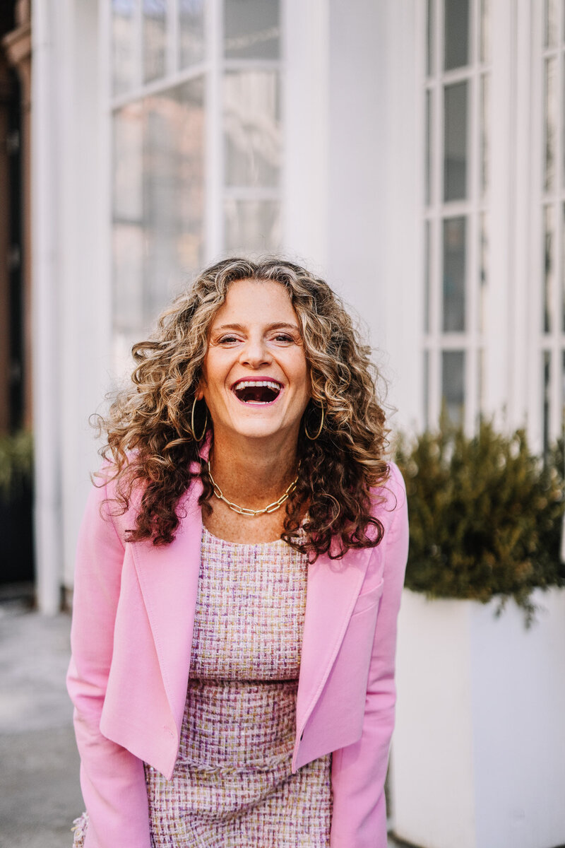 Woman smiling with a pink blazer