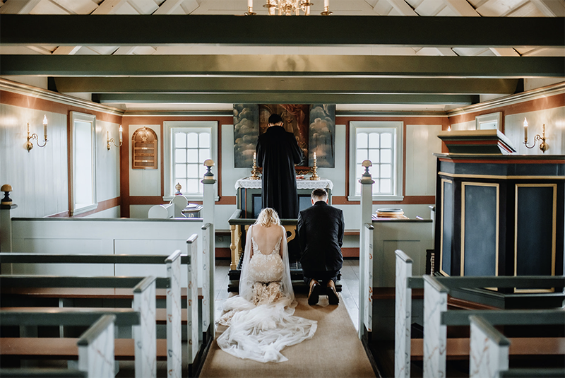 Couple is in a black wooden church on their wedding ceremony in Iceland