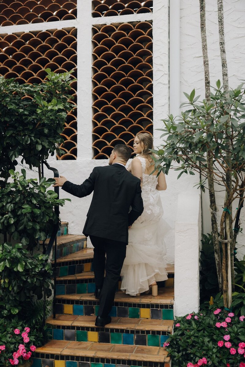 bride and groom walk up the stairs after their ceremony