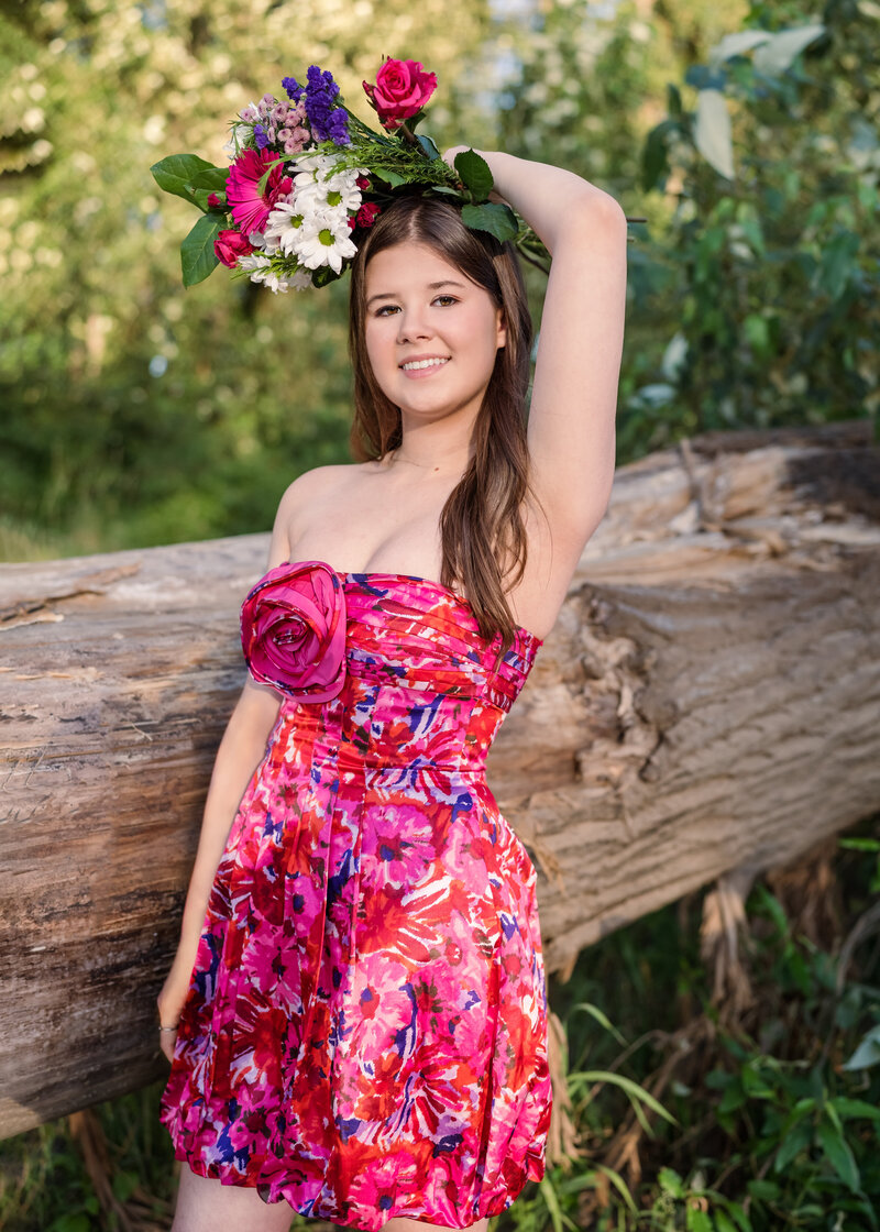 Highschool girl with flowers in field with pink dress. 