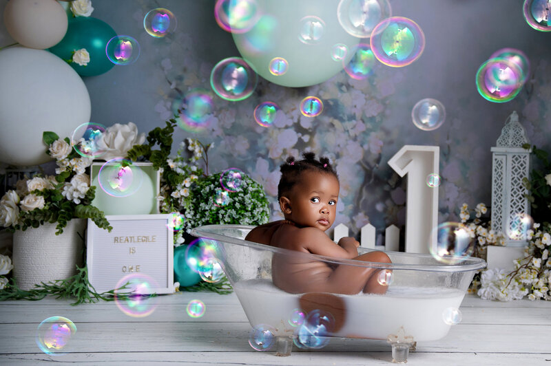 Cake smash and milk bath in clear tub, green and white setup