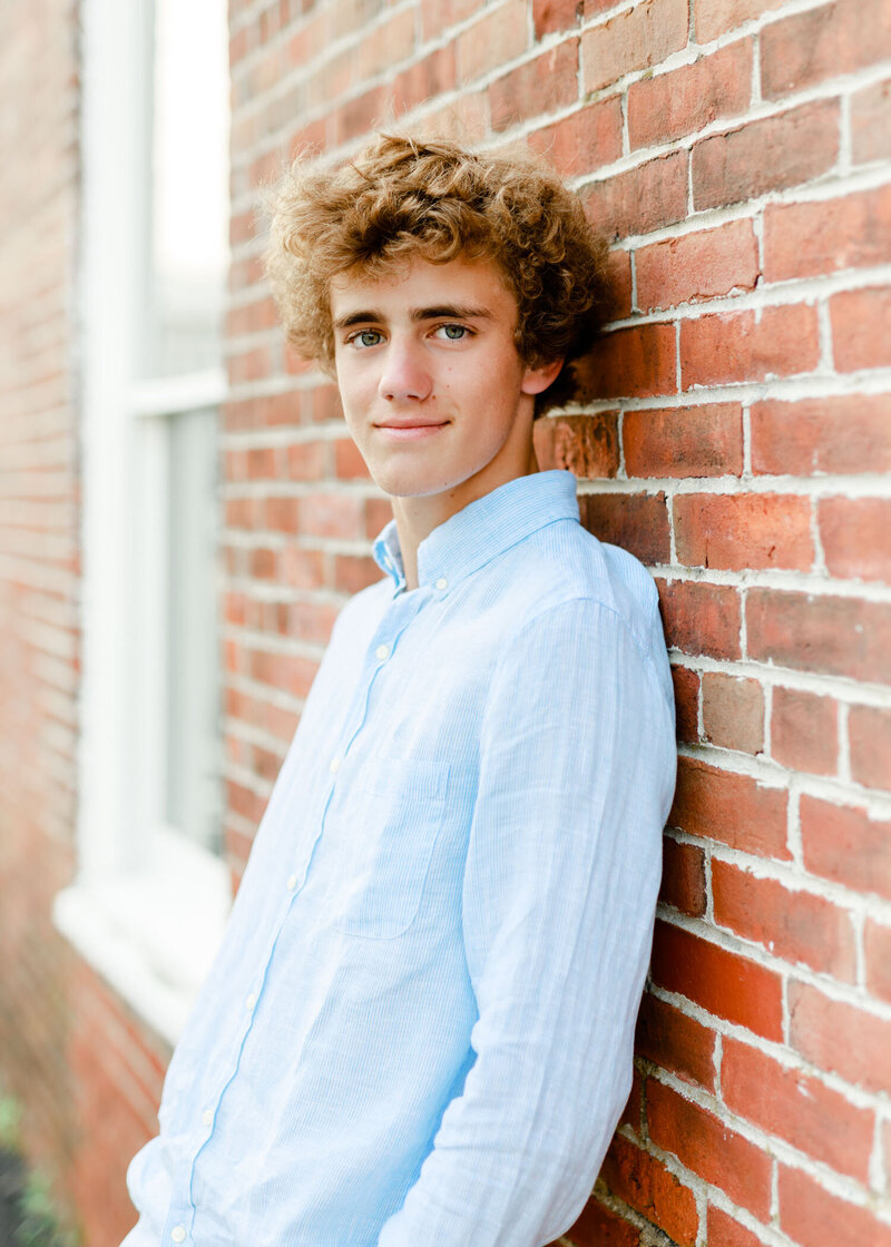 Image by South Shore senior photographer Christina Runnals  | Guy leaning against brick wall