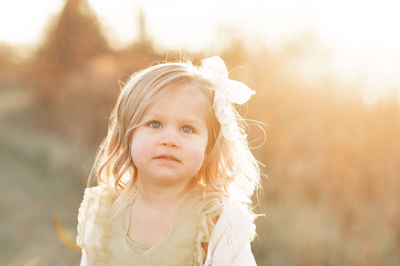 young girl smiles in yellow sunset haze