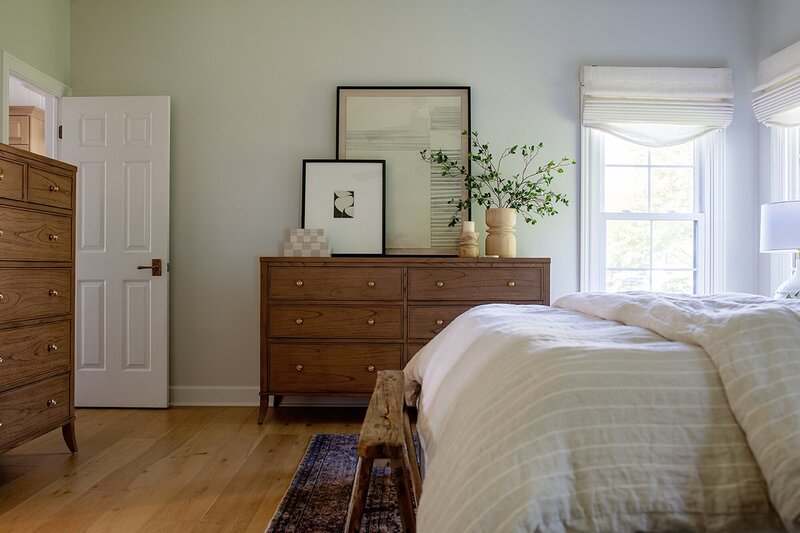 Modern Heritage style bedroom with a wooden dresser and white bed.