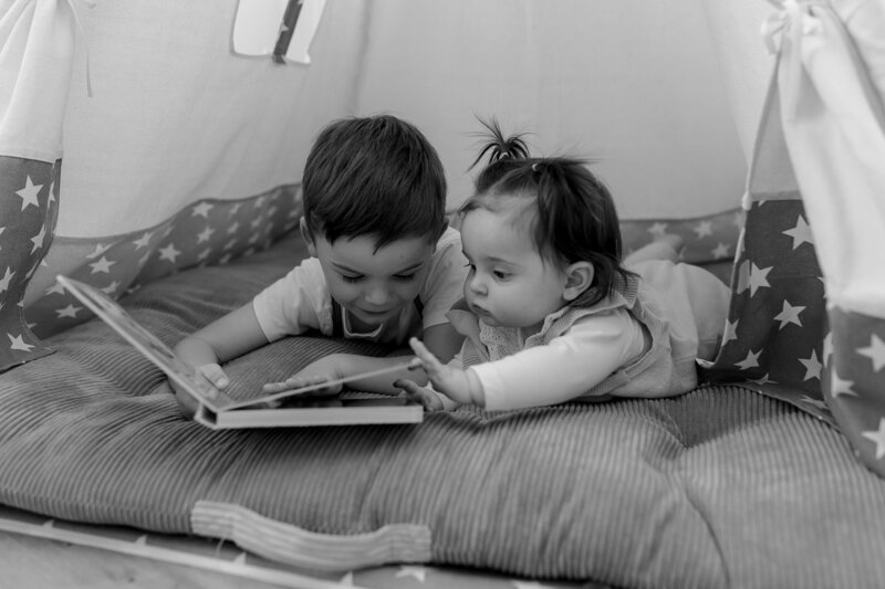 Schwarz weiss Bild von Bruder und Schwester  wie sie ein Buch angucken
