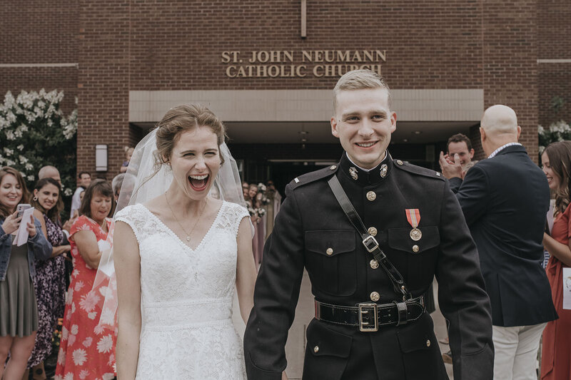 bride and groom smiling outside of a Catholic church
