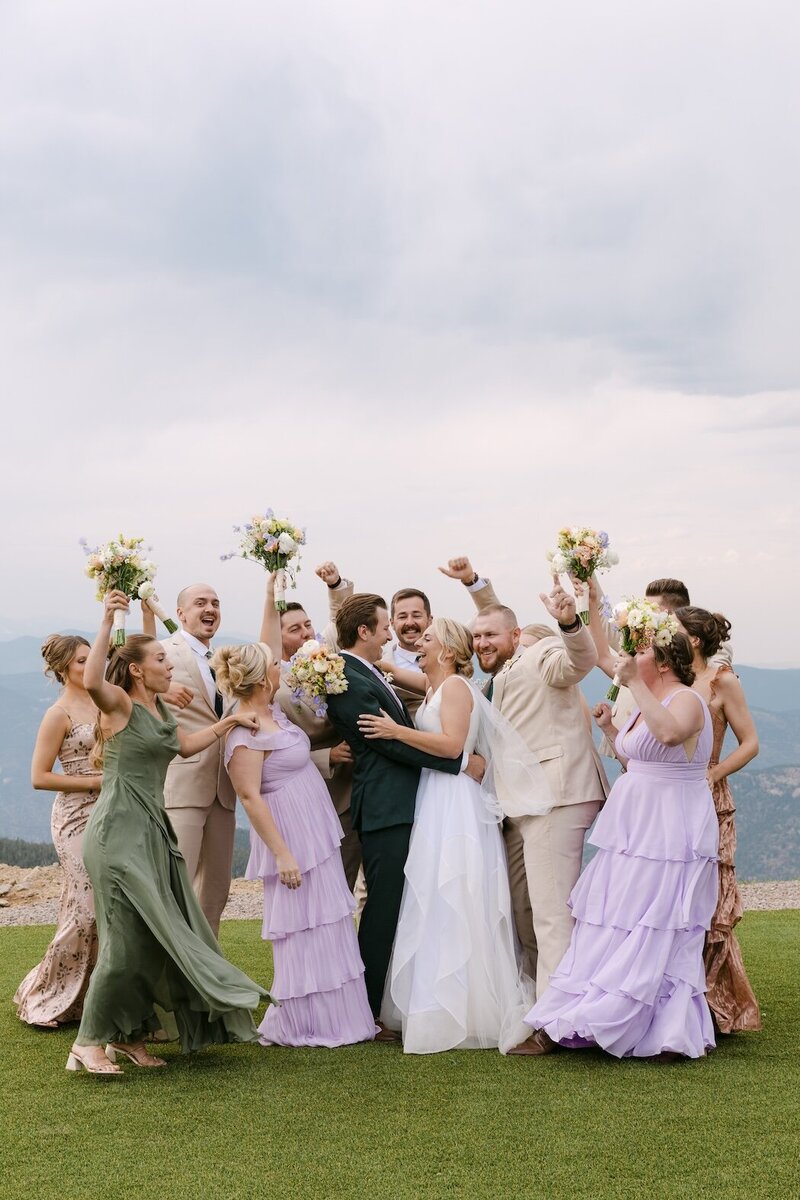 Wedding party celebrating in pastel dresses on the mountaintop at Echo Mountain Ski Resort — Colorado mountain wedding photographer