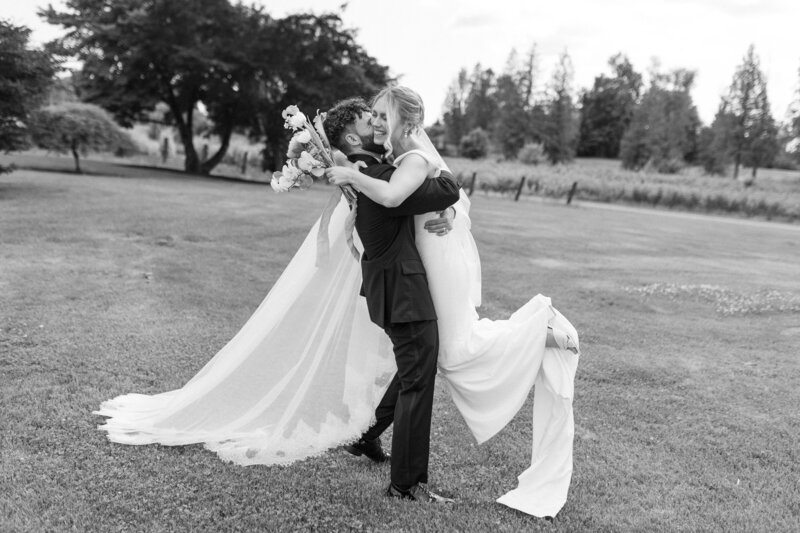 black and white editorial shot of groom catching bride after the ceremony shot by Langley Wedding Photographer Jillian Nielsen Photography
