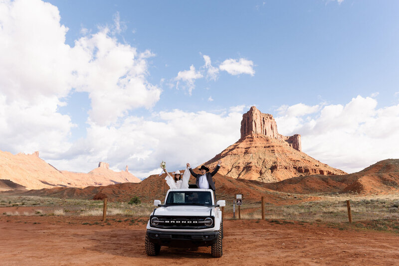 Bride and groom eloping in the dessert in a Bronco, taken by Moab elopement photographer, Forever Framed by Rachel