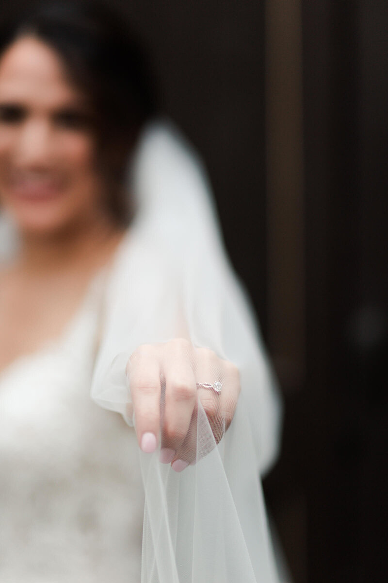 bride holds out her veil during her bridal session at The Bell Tower on 34th in Houston by Swish and Click Photography